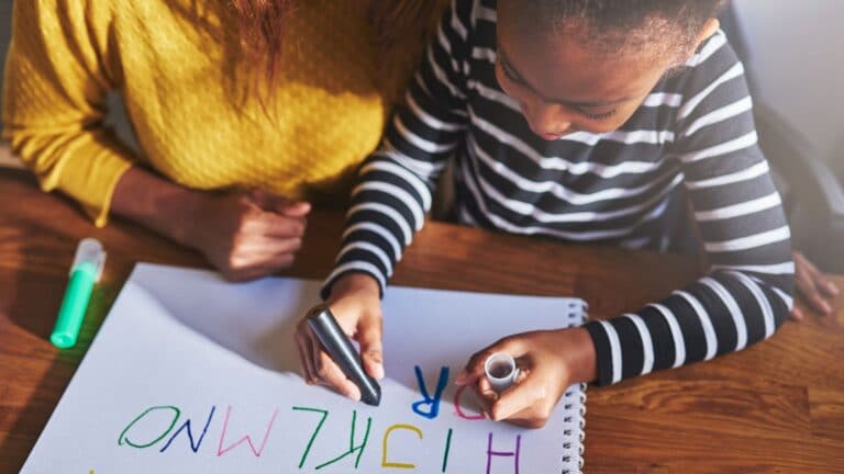 The Alphabetic Principle-a girl writing alphabet letters with her mother