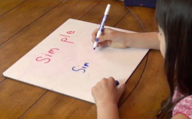 Multisyllable word reading practice on dry erase board