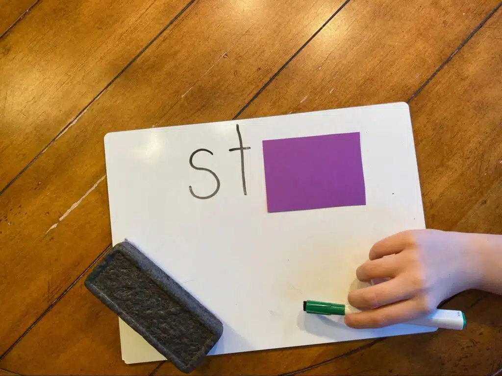 A whiteboard with the word “stop” written on it but a card partially covers the word to hint at the Blend As You Read decoding strategy