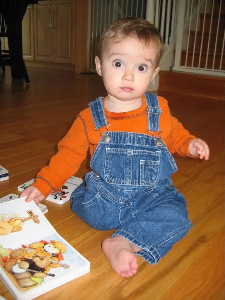 Toddler sitting on floor with a book
