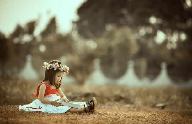 Child reading in dress up clothes