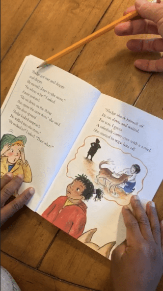 Book open with teacher pointing to words with pencil