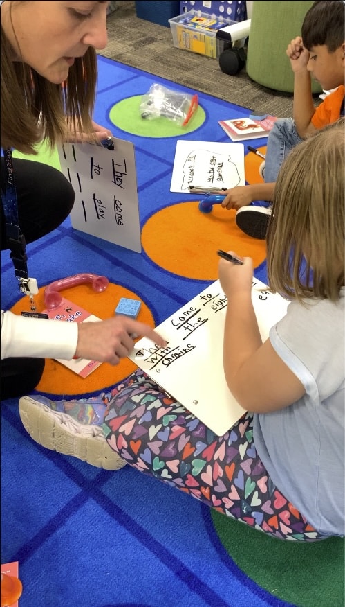 Teacher working with students to write key sentence for Sort It on their boards!