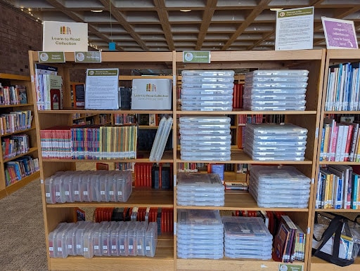 Clear storage bins organizing decodable book sets for checkout
